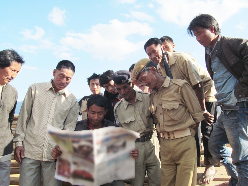 Villagers, including Village Guards, of a remote village in Tuensang district take a peek into the pages of a Nagaland-based daily. (Morung File photo)
